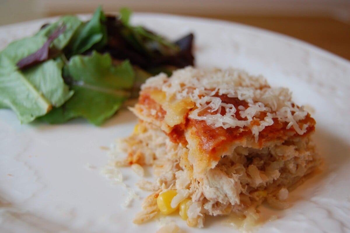 One piece of Chicken Enchiladas with a side salad.