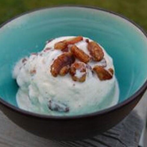 Maple pecan ice cream in a bowl topped with whole pecans