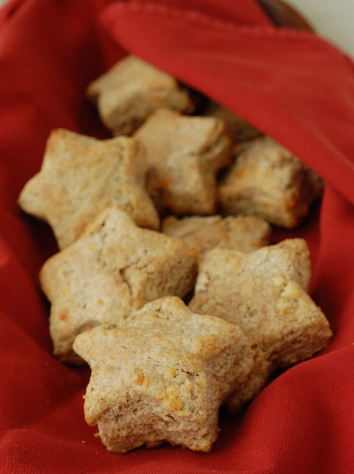 A handful of buttermilk cheese biscuits in the shape of a stars in a red napkin.