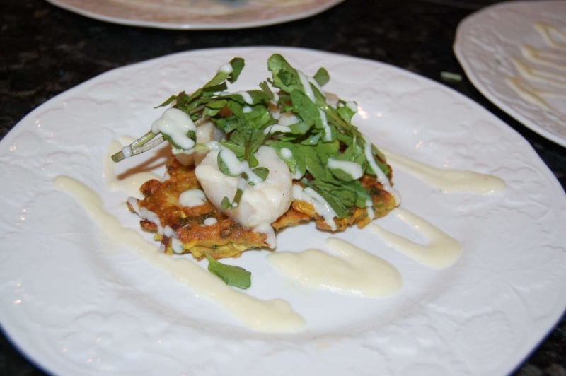 Seared scallops, squash fritters, and lime yogurt sauce topped with some greens. 