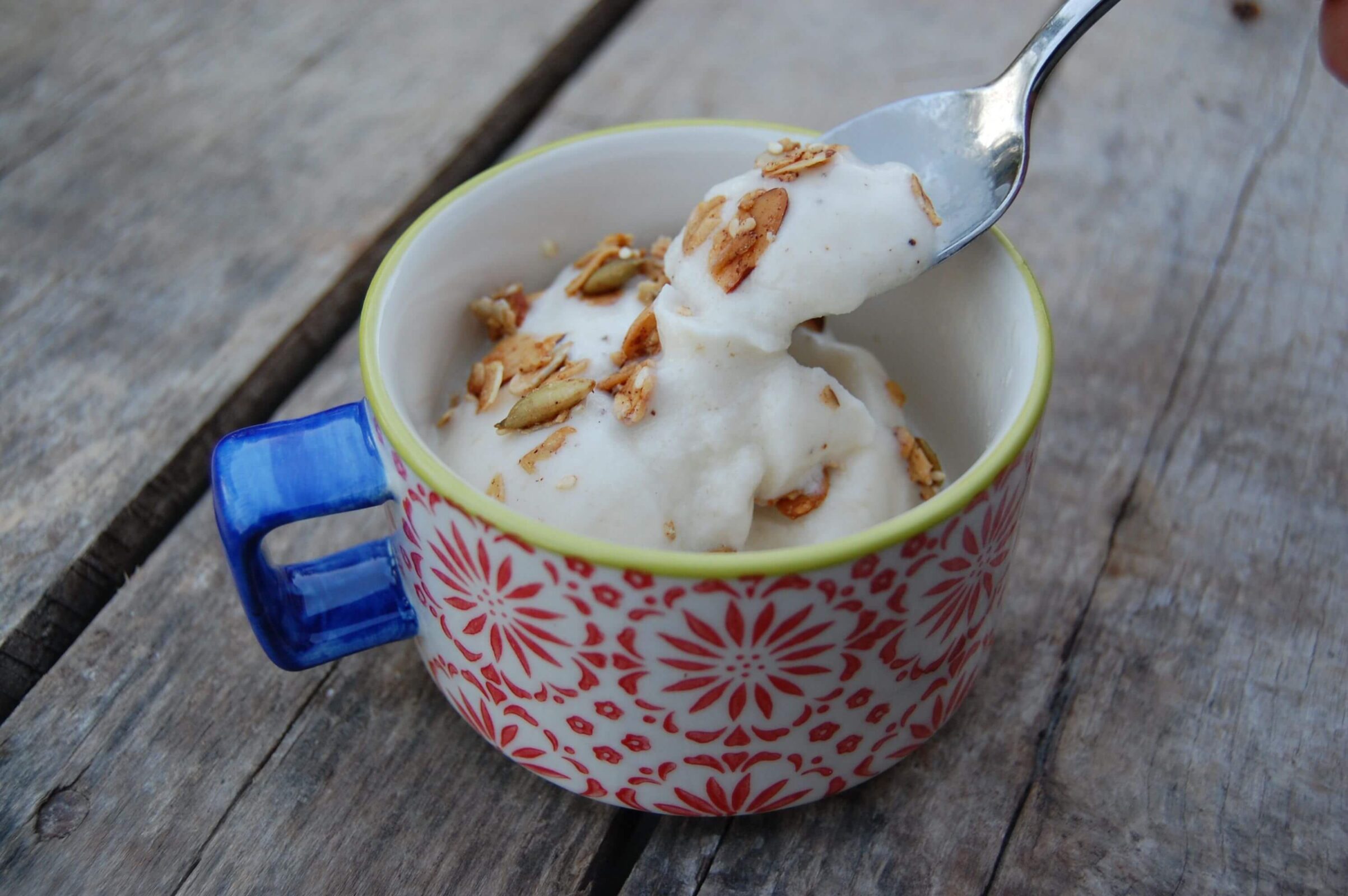 Homemade Banana Ice Cream in a decorative cup topped with granola.