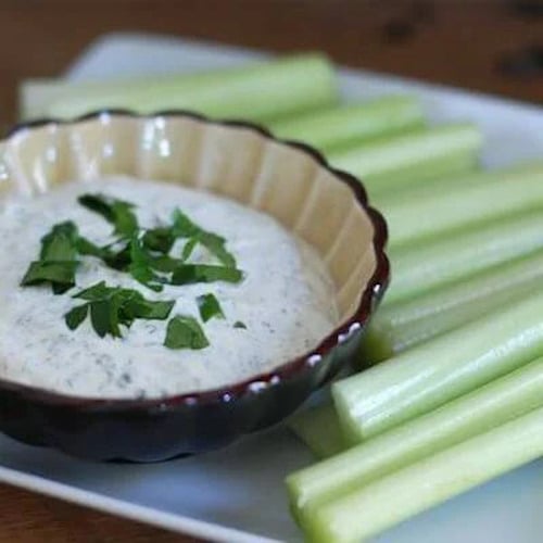 homemade ranch dip in a bowl with celery sticks on the side