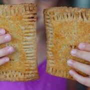 Little girl holding up two homemade toaster pastries.