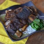 Asian short ribs on a plate with noddles and broccoli
