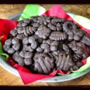 A large batch of chocolate peppermint cookies on a a plate with red and green napkins.