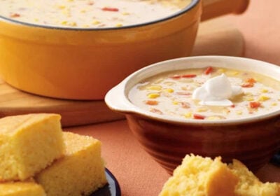 Corn chowder in a bowl with a side of corn bread