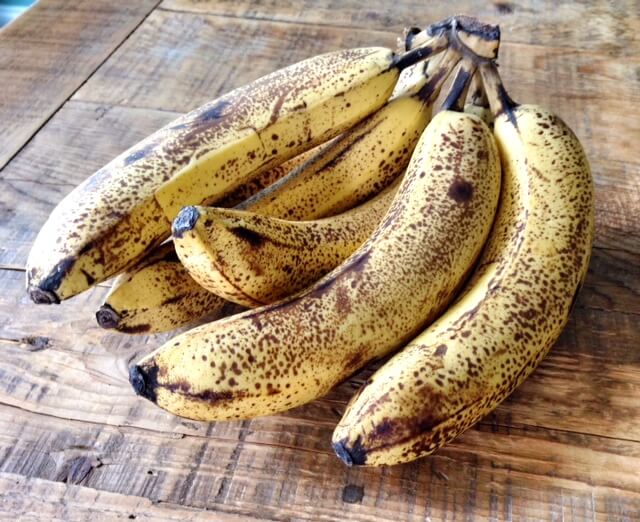 overripe bananas on a wooden farm table