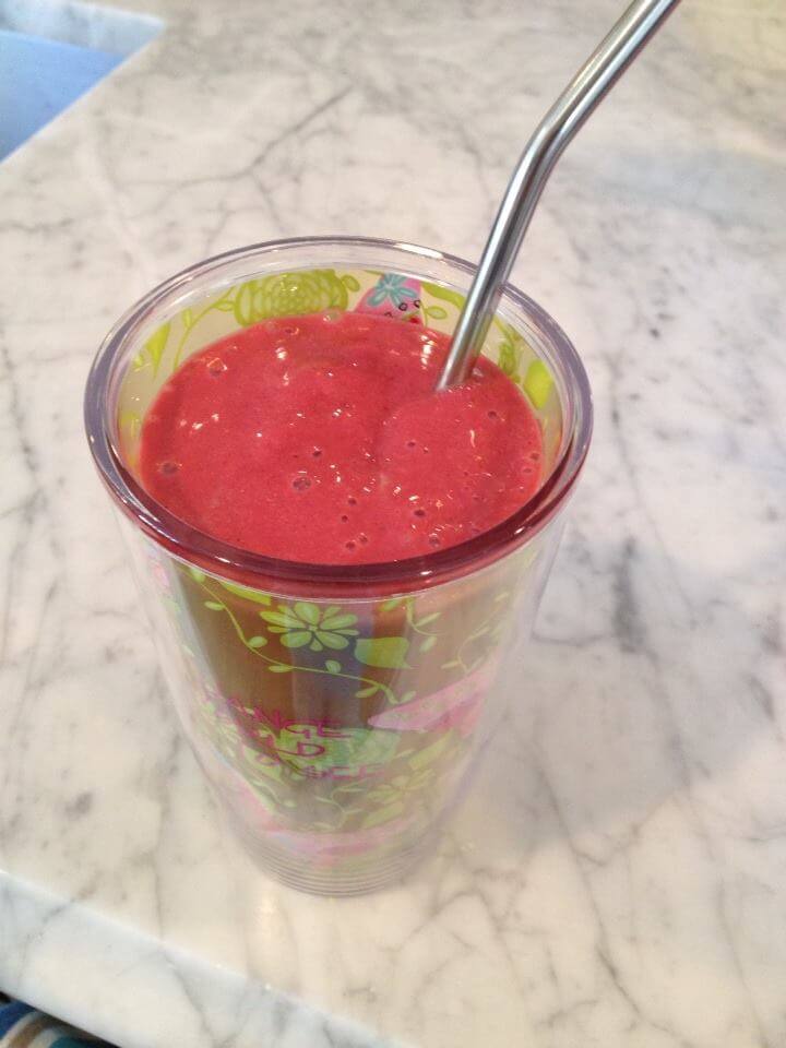 A refreshing Banana Berry smoothie in a colorful cup with a metal straw.  
