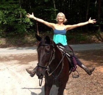 Dr. Kilbane sitting on a black horse about to go riding. 