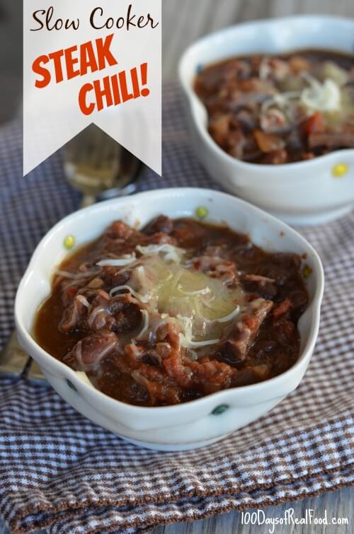 Two bowls of hot steak chili topped with cheese.