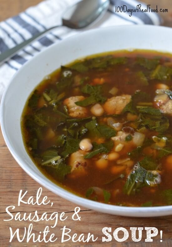 Kale, Sausage and White Bean Soup in a white bowl with a spoon and cloth napkin.