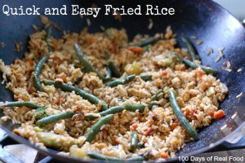 Homemade fried rice in a wok being made on the stove.