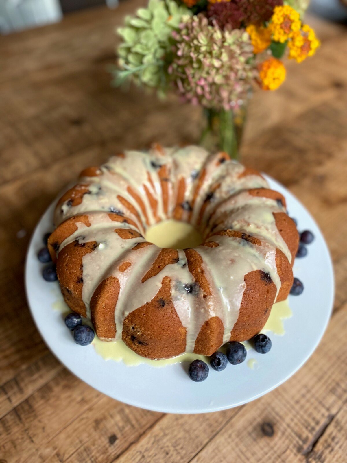 Blueberry Lemon Bundt Cake drizzled with lemon cream sauce with fresh blueberries. 