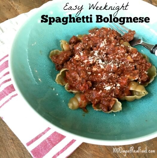 Homemade spaghetti Bolognese topped with shredded cheese.