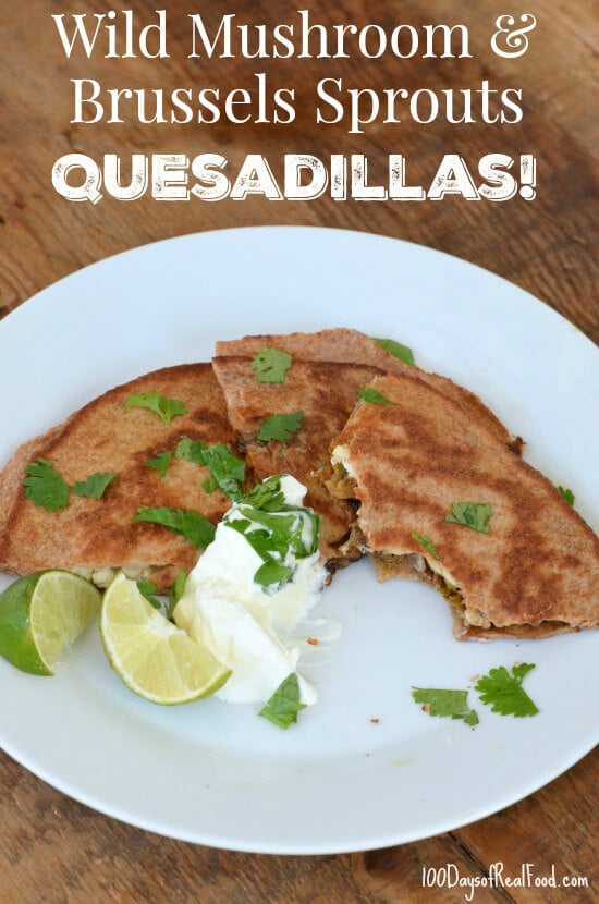 Wild Mushroom and Brussels Sprouts Quesadillas topped with cilantro, sour cream, and a side of lime halves.