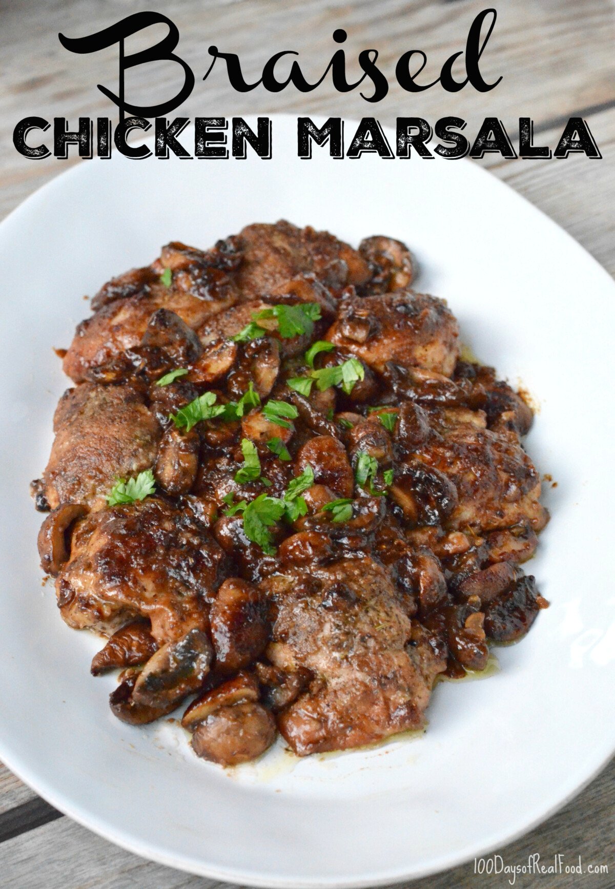 Braised Chicken Marsala on a white plate topped with chopped parsley