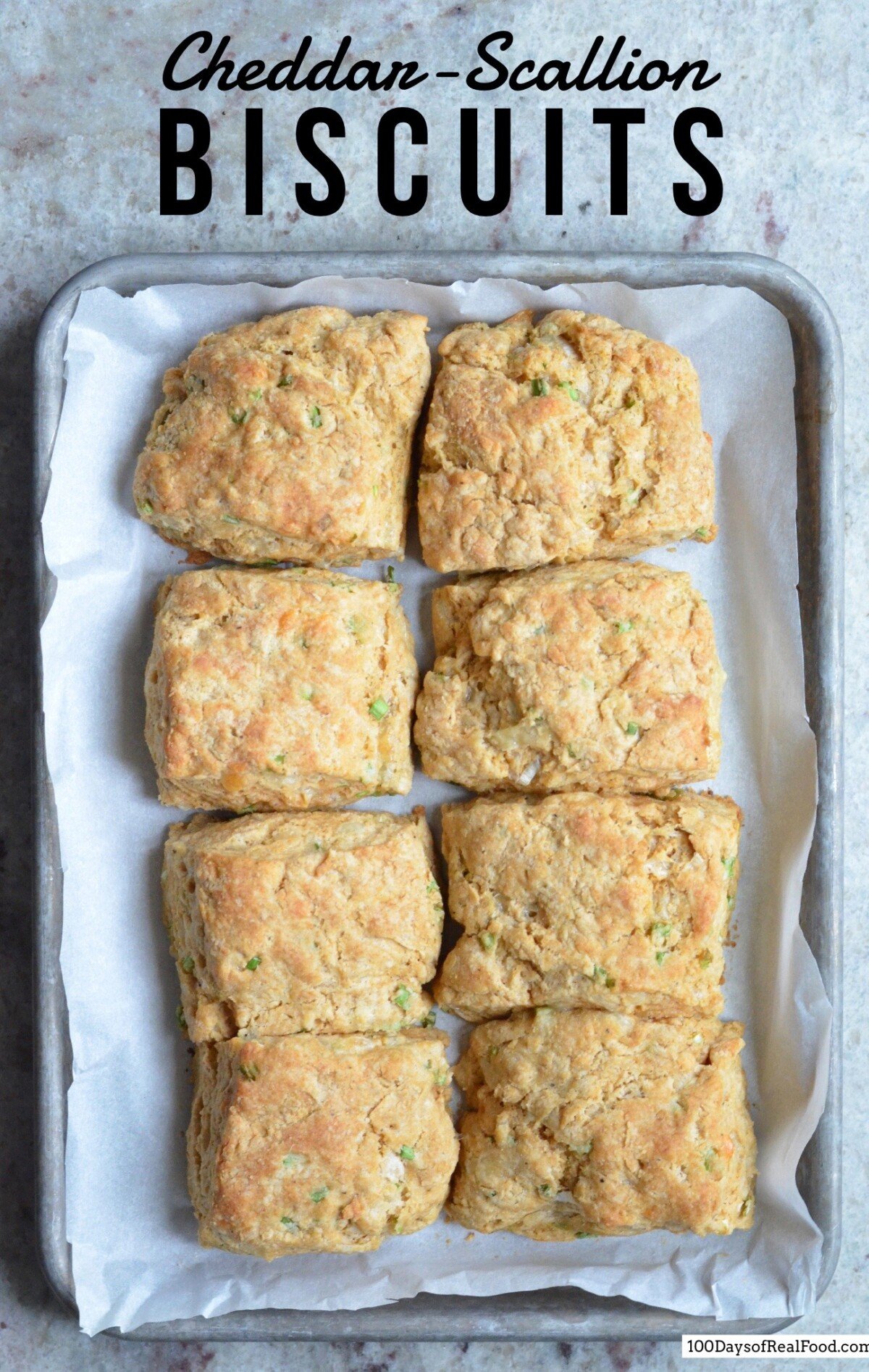 cheddar-scallion biscuits on a baking sheet.