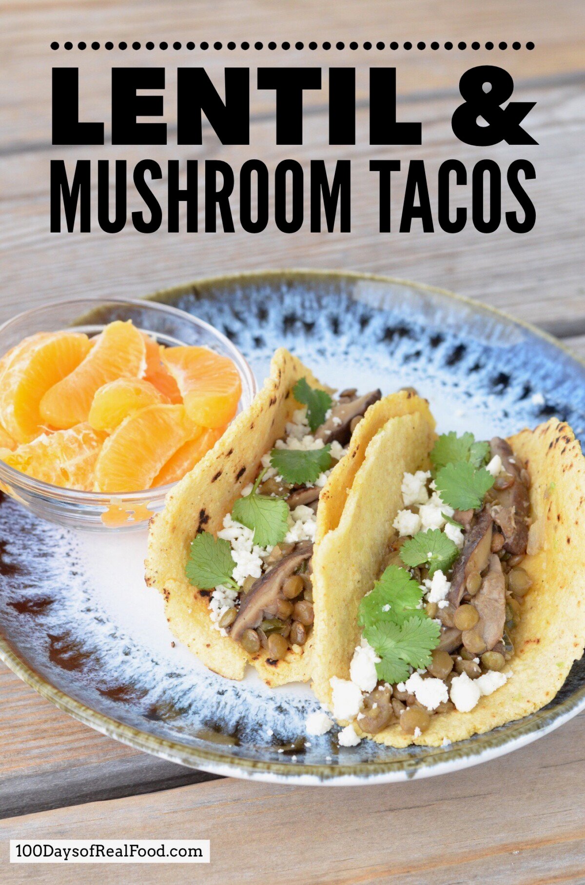 Lentil and Mushroom Tacos topped with cheese and cilantro in corn tortillas with a side of orange slices.