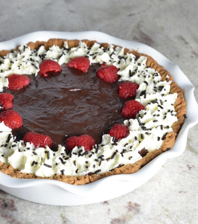  Chocolate pudding pie with raspberries, whipped cream and chocolate sprinkles.
