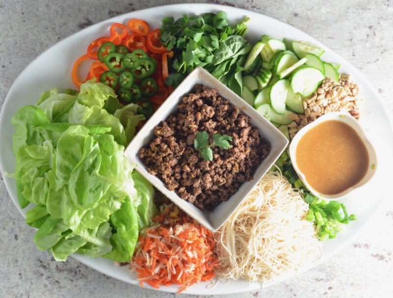 Seving Vietnamese beef lettuce wraps with a variety of veggies on a platter