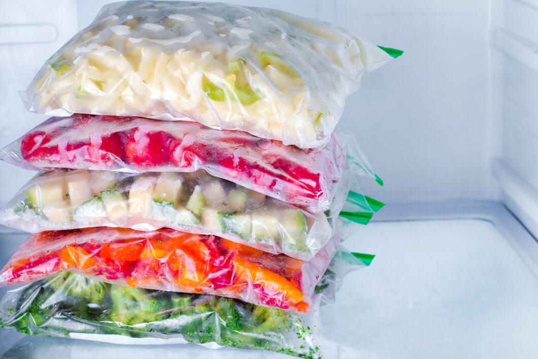 Bags with frozen vegetables in freezer