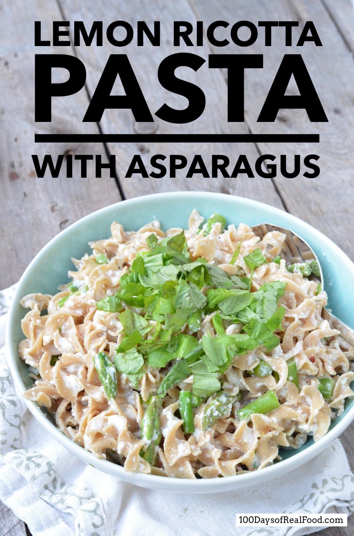 Lemon Ricotta Pasta topped with with asparagus and basil in a blue salad bowl. 