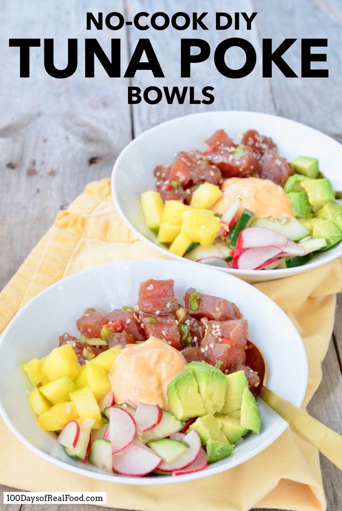 DIY Tuna Poke Bowls with cucumbers, avocados, mango, radishes, topped with a creamy sauce in two white bowls. 