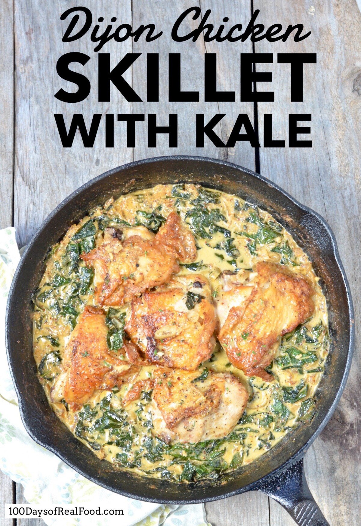 Cast iron skillet with crispy baked chicken pieces and kale in a creamy dijon sauce.