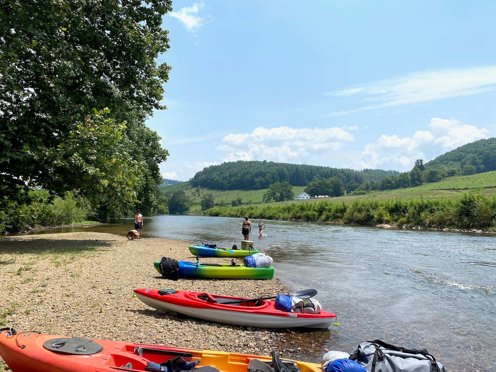 Four kayaks lined up on the banks of the river in North Carolina.