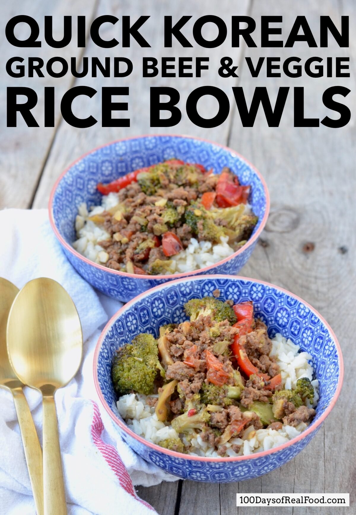 Two blue bowls filled with white rice, ground beef, broccoli with a Korean flavor. Two gold spoons and a white cloth napkin sitting next to them.  