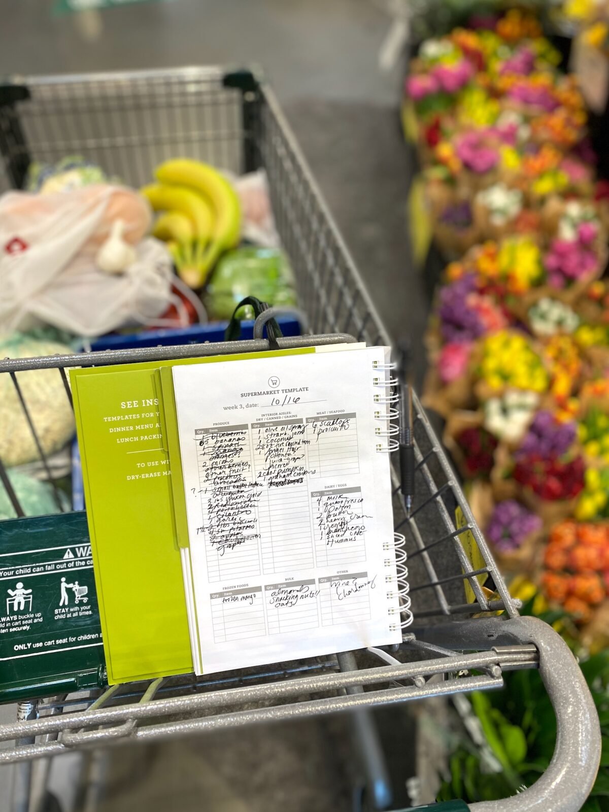 Meal Planner sitting in grocery cart at the store.