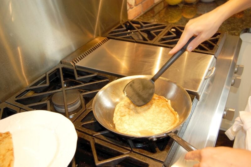 Flipping whole wheat crepes in a frying pan