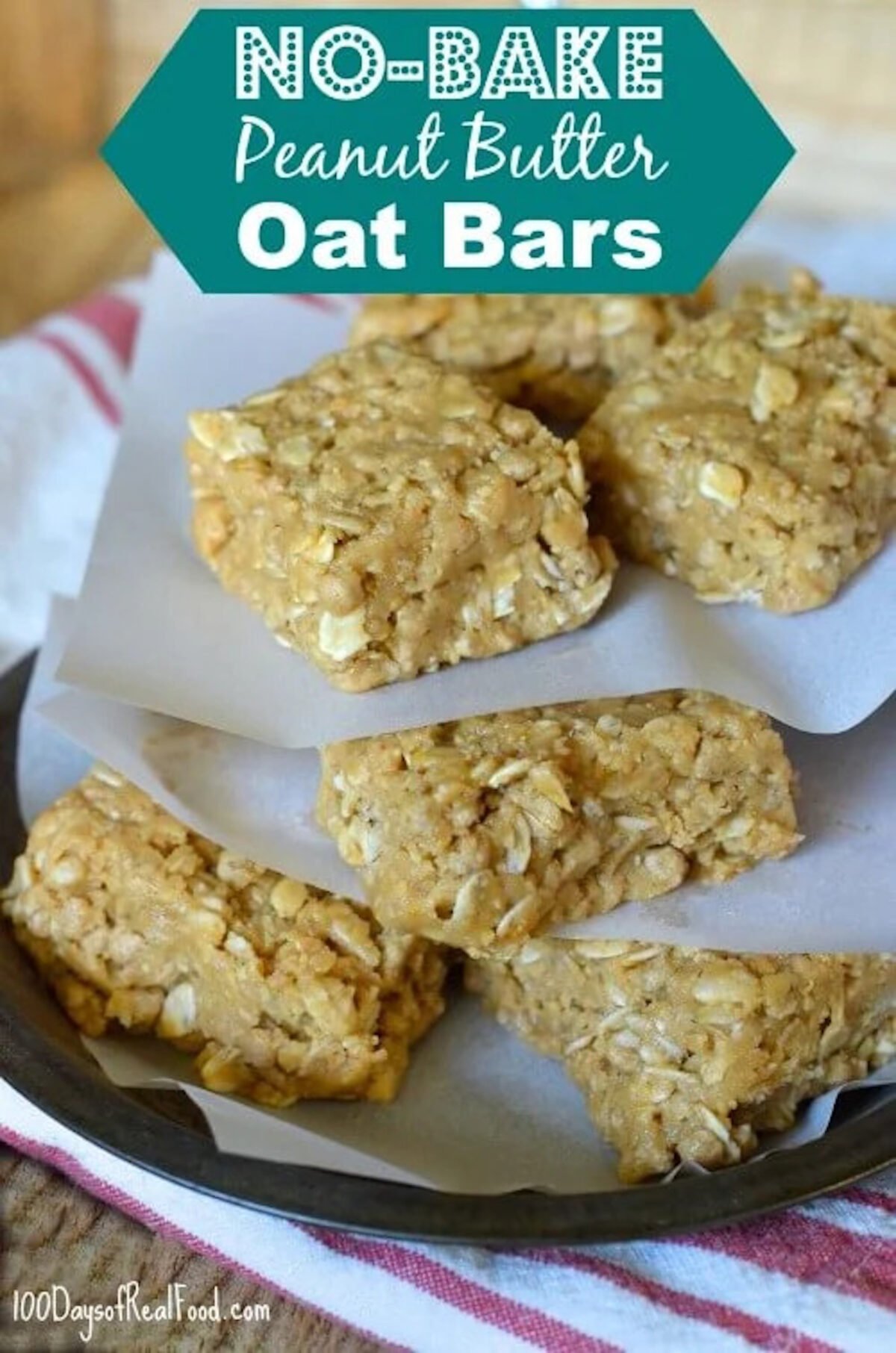 A pile of homemade peanut butter oat bars layered between parchment paper. 