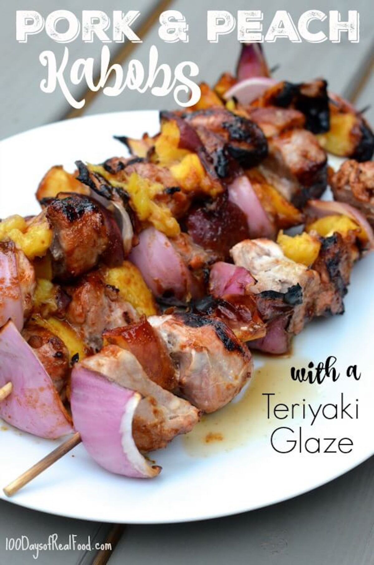 Three skewers of pork, peach slices, and onions that just came off the grill