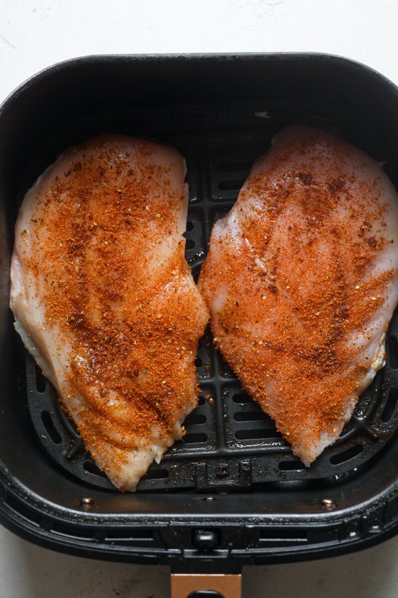 Air fryer basket with chicken.