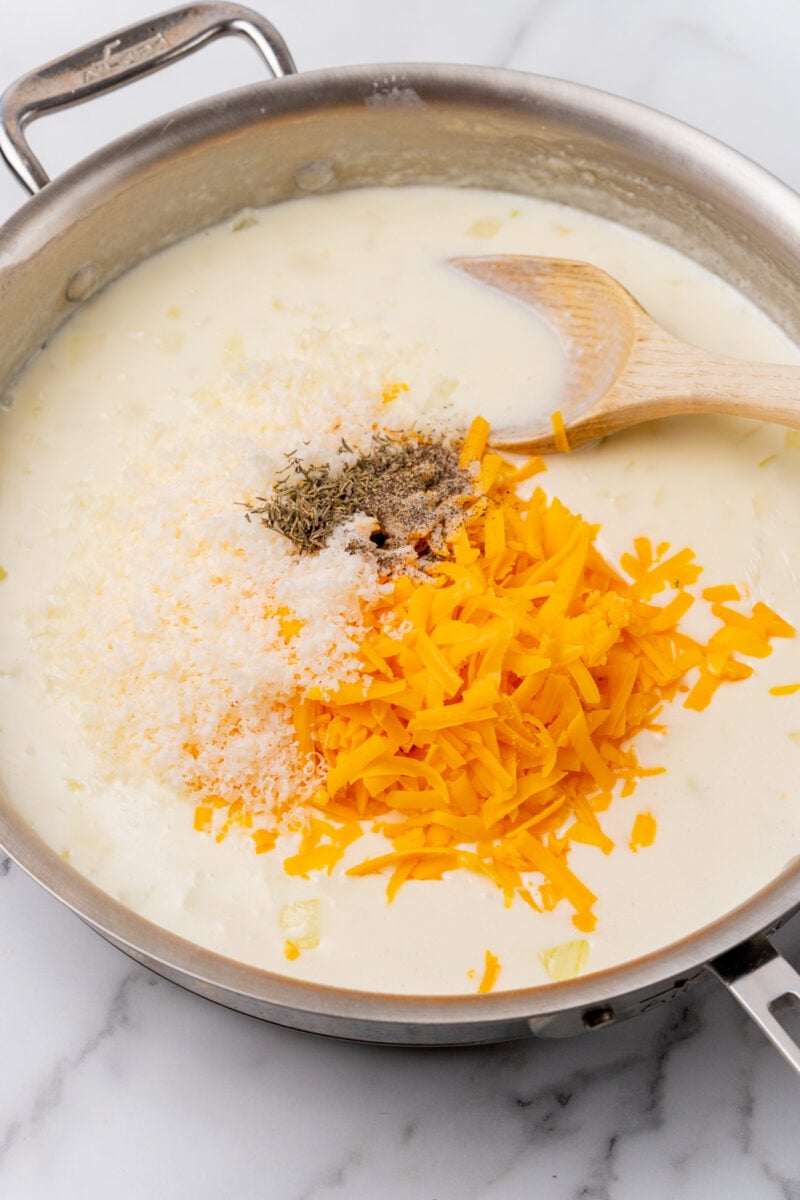 Cheese and herbs in a frying pan.