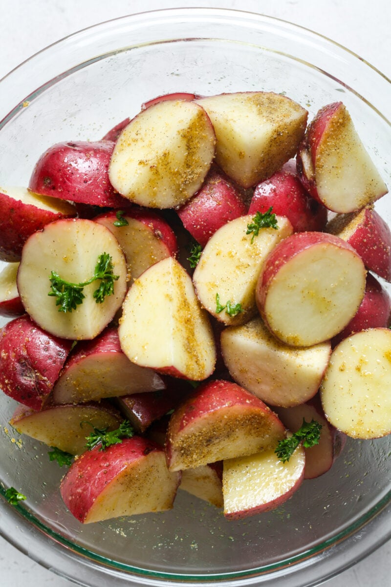 Halved potatoes with oil and seasonings.