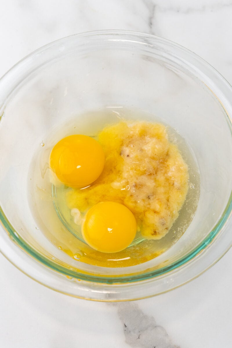 Eggs and mashed banana in bowl.