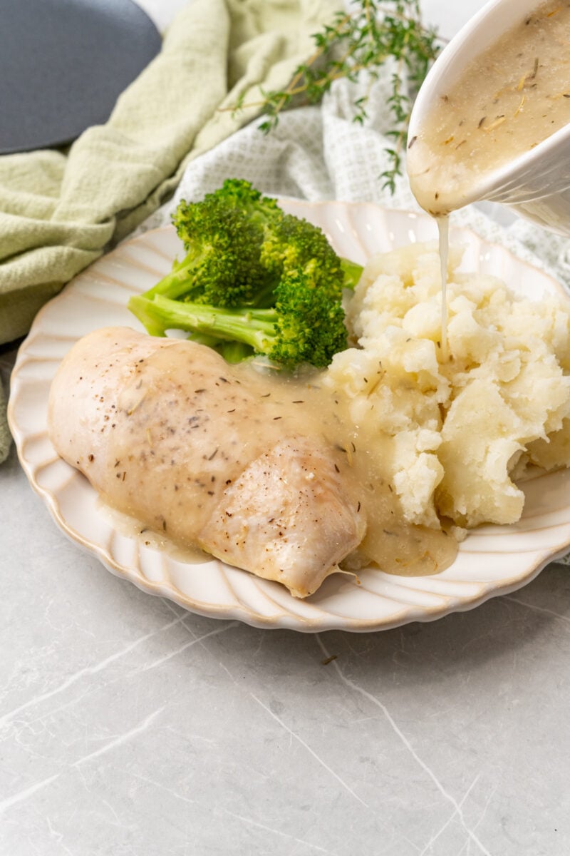 Gravy poured on mashed potatoes.