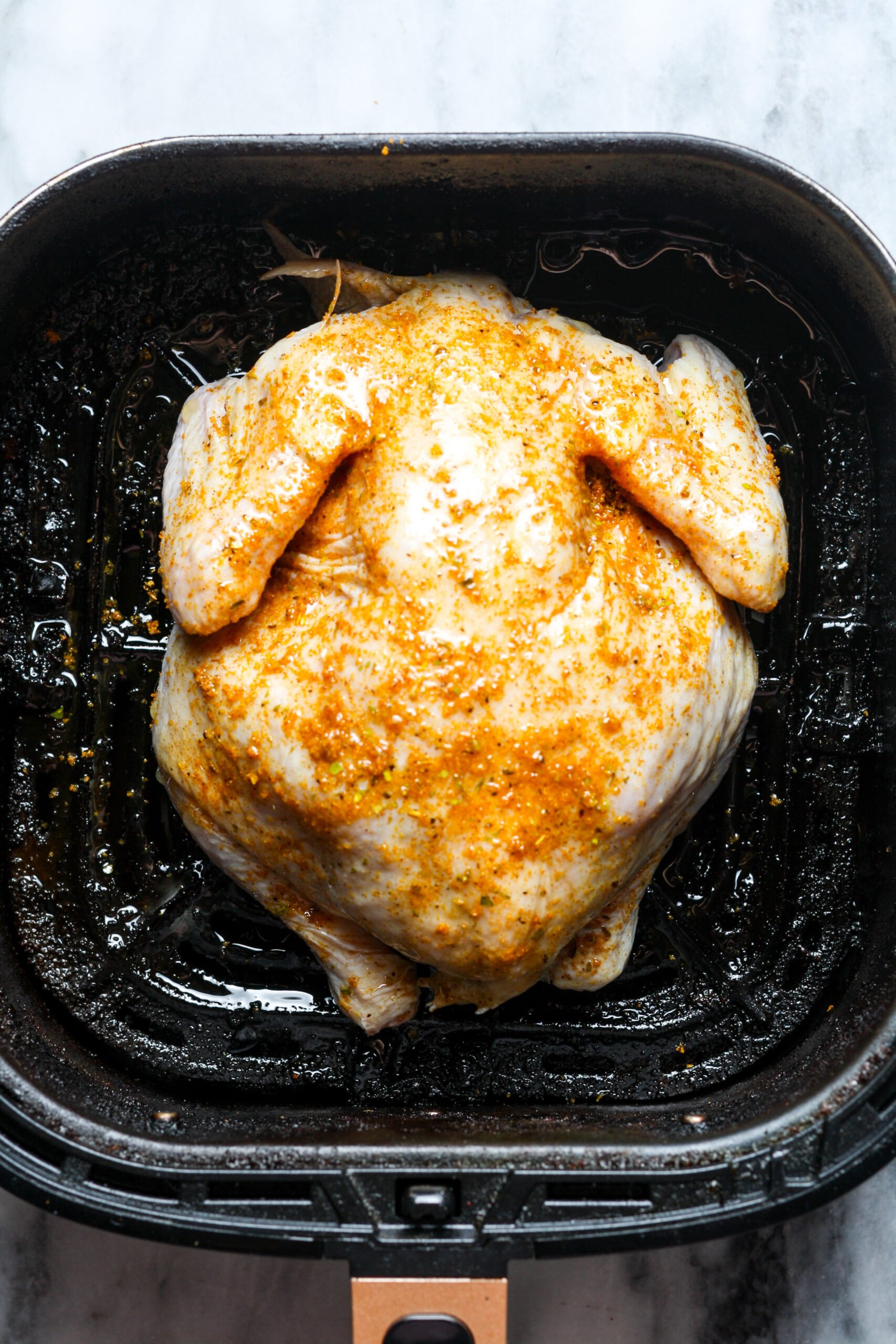 Chicken in air fryer basket.