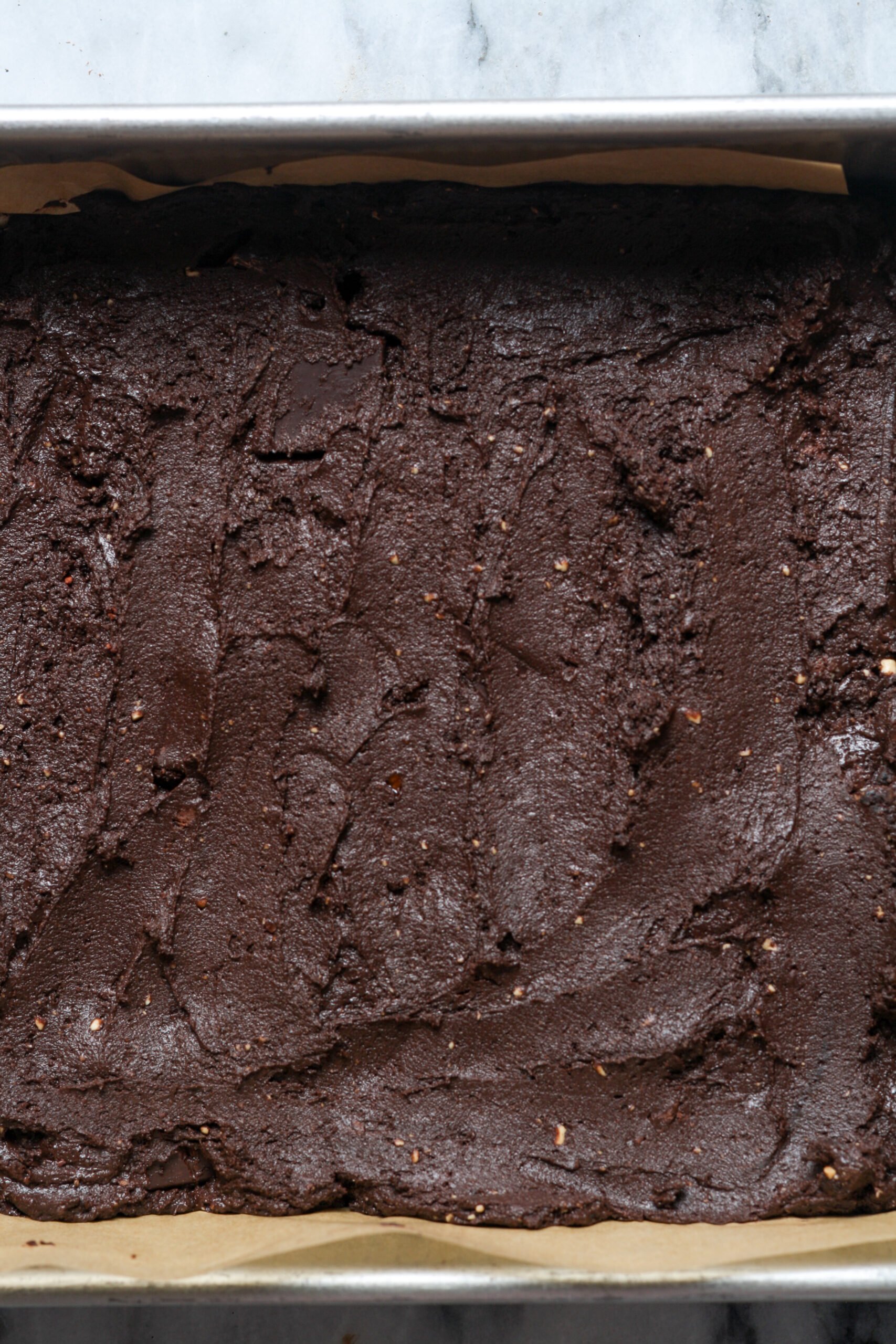 Square pan with chocolate batter.