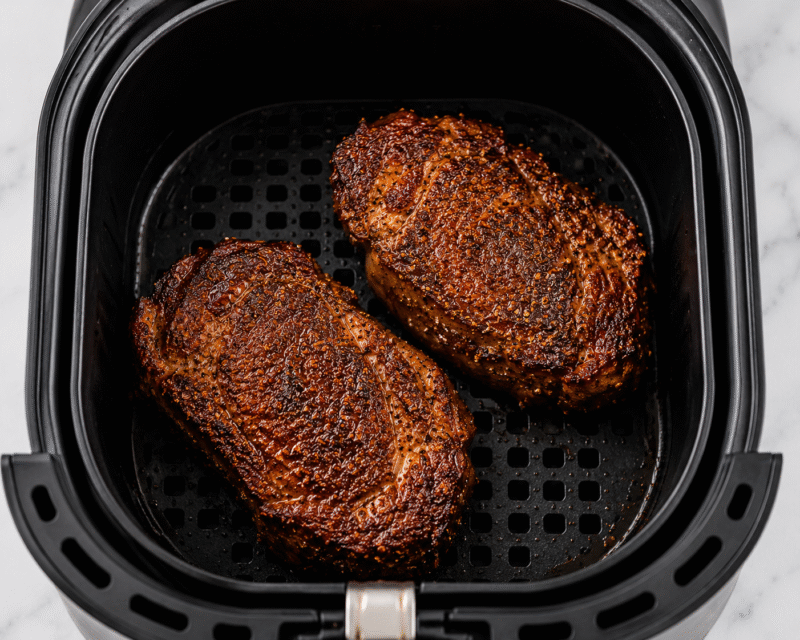 Air fryer ribeye steak in basket.